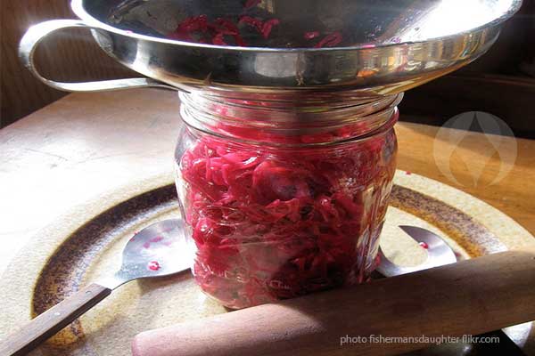 filling jar with red cabbage sauerkraut